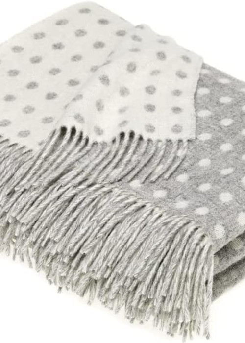 a grey and white blanket with white polka dots