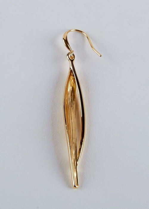 a gold earring on a white surface