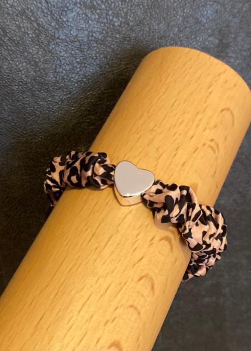 a bracelet on a wooden tube