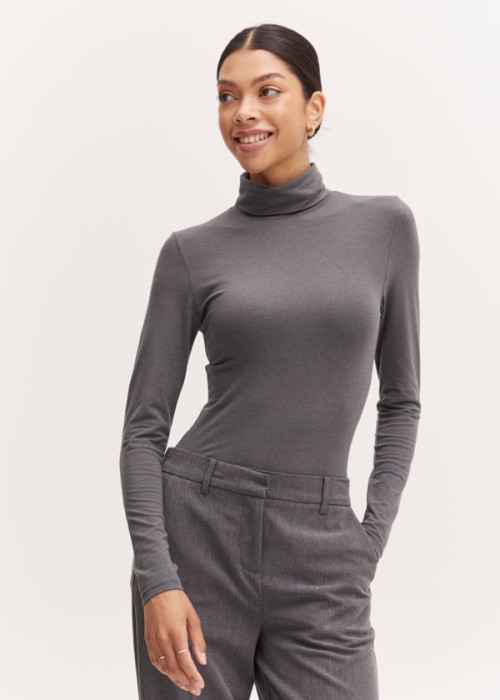 a woman in a grey turtleneck