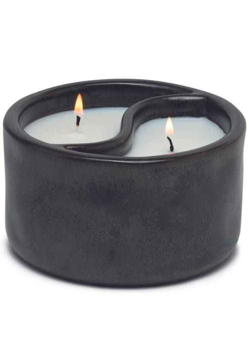 a black candle holder with two lit candles