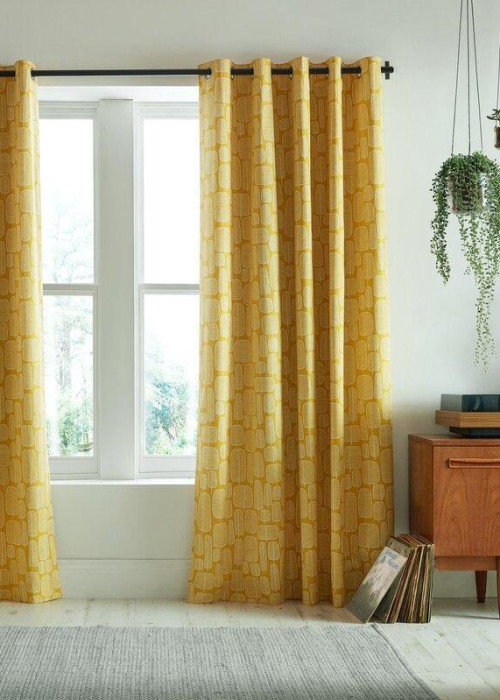 a room with yellow curtains and a cabinet