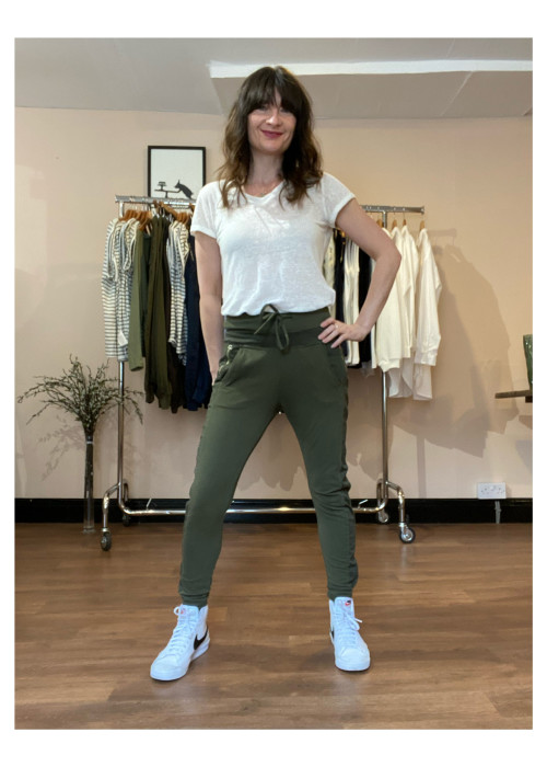 a woman standing in front of a rack of clothes