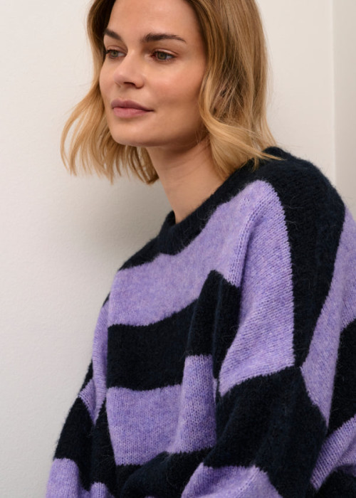 a woman in a purple and black striped sweater