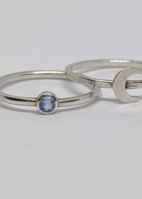 a couple of silver rings with a blue stone in the middle