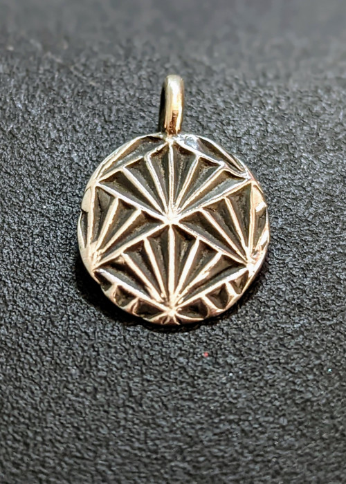 a gold medallion with a diamond design