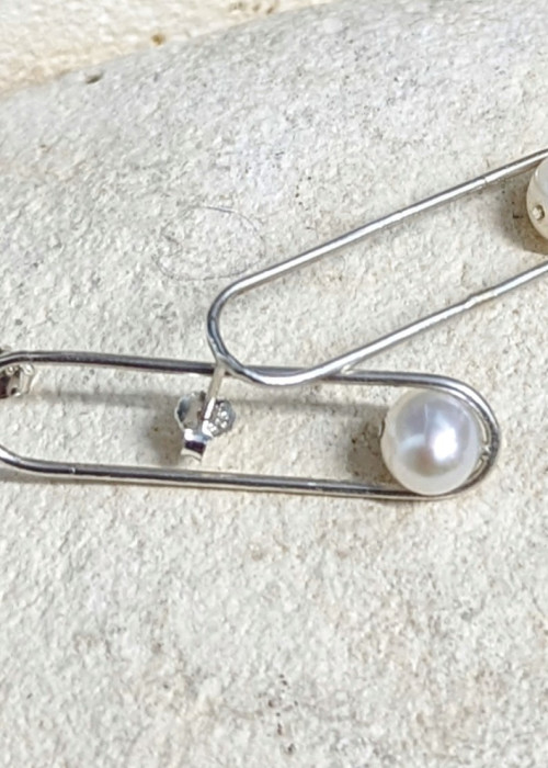 a pair of safety pins with pearls