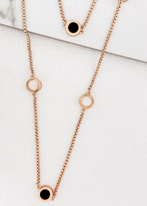 a gold necklace with a black circle on it