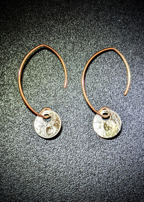 a pair of earrings on a black surface