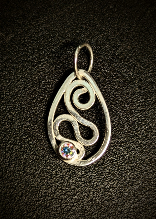 a silver pendant with a colorful gem