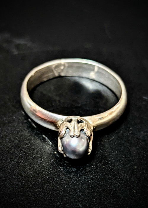 a silver ring with a pearl in it