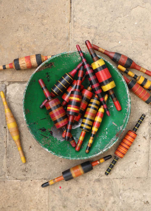 a bowl of colorful wooden bobbins