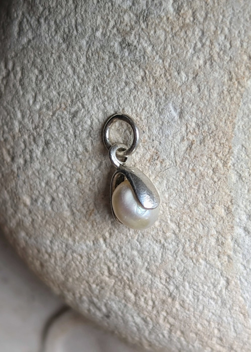 a pearl in a silver pendant