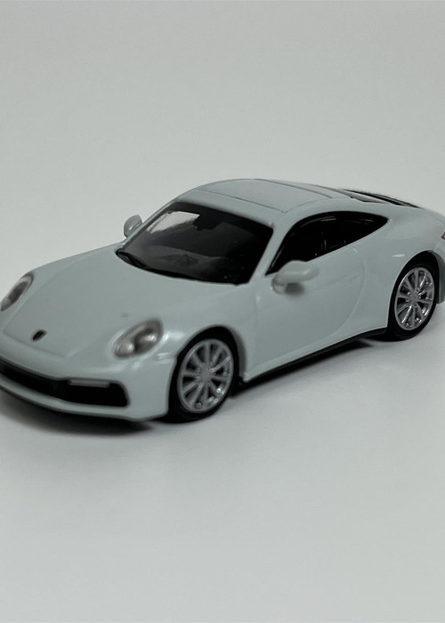 a white toy car on a white surface