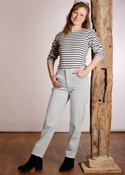 a woman leaning against a wooden post