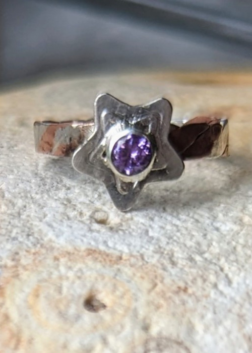 a ring with a purple stone in the middle