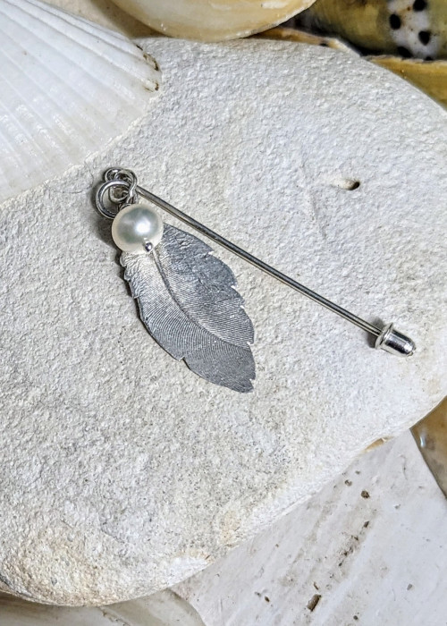 a feather pendant on a rock