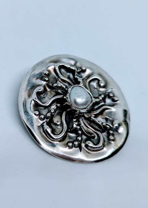 a silver button with a pearl