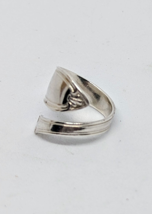 a silver ring on a white surface