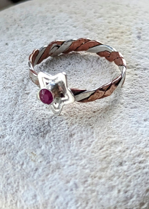 a ring with a star and a red stone