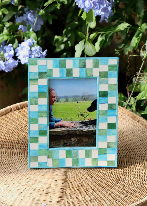 a picture frame with a picture of a woman sitting on a wicker chair