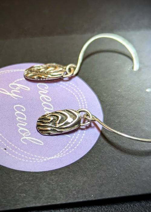 a pair of earrings on a purple paper