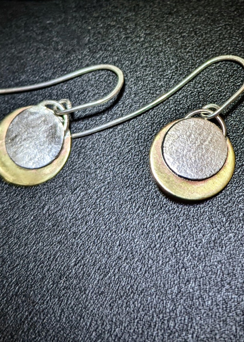 a pair of earrings on a black surface