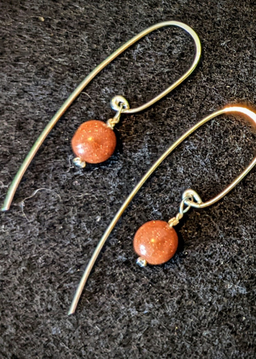 a pair of earrings on a black surface