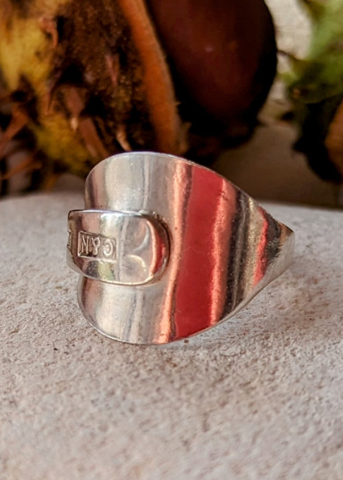 a silver ring on a white surface