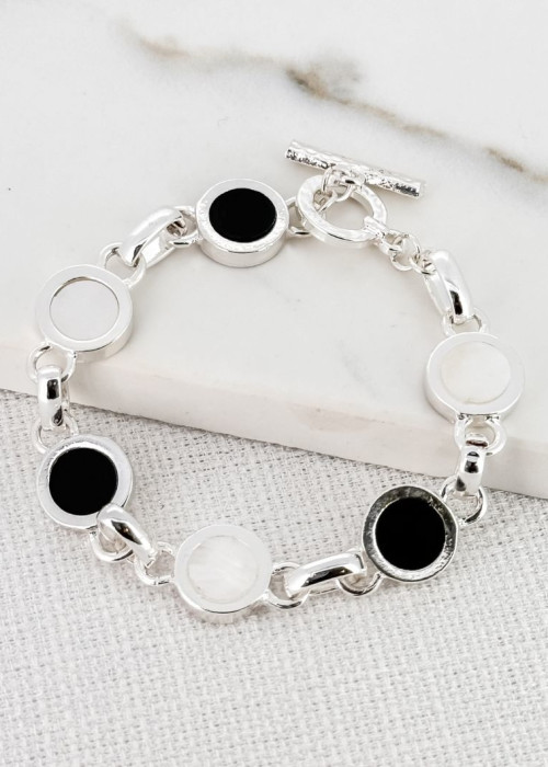 a silver bracelet with black and white circles