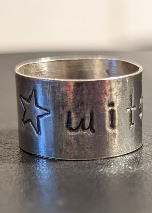 a silver ring with a star and a star engraved on it