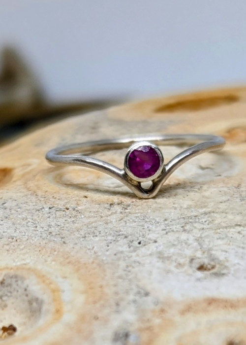 a silver ring with a purple stone in the middle