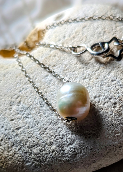 a pearl necklace on a rock