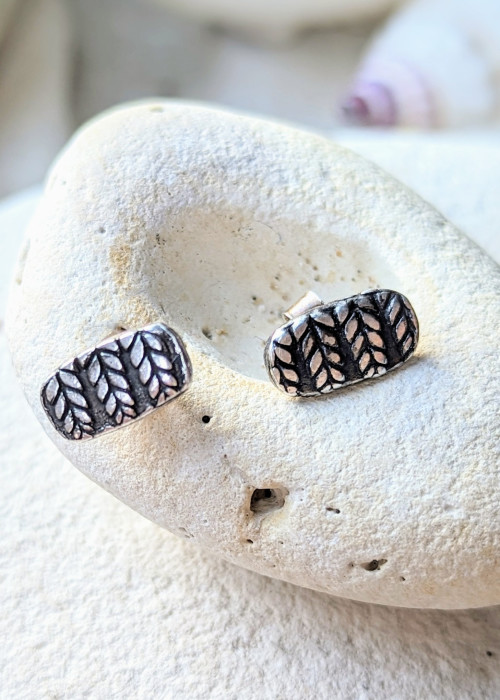 a pair of earrings on a rock