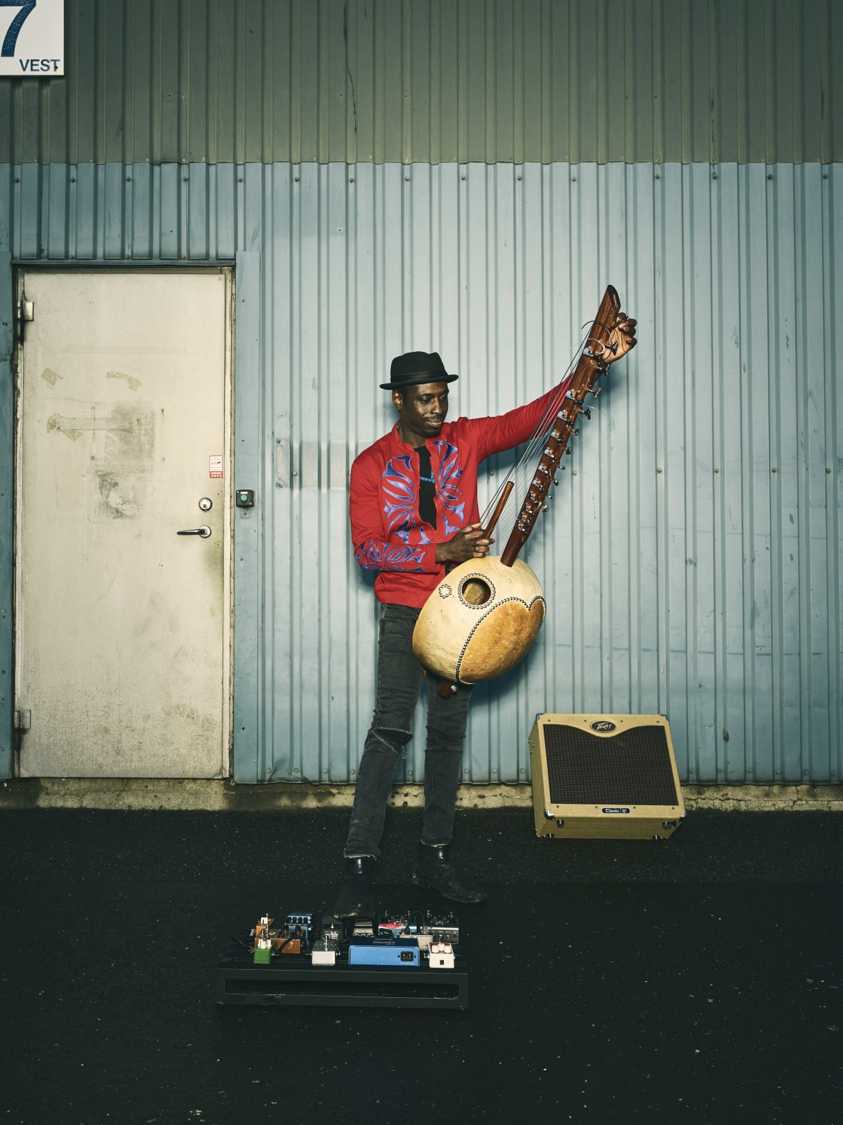 Dawda Jobarteh poses with his kora, pedalboard, and Peavey Classic 30 II amp.