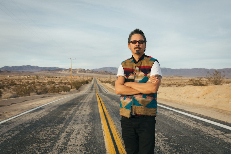 Guerrero standing arms crossed on an empty road