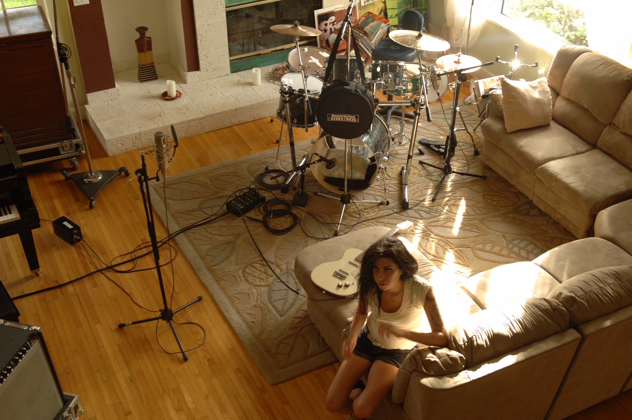 Winehouse sitting on a couch in the home studio setup used for part of Back to Black.