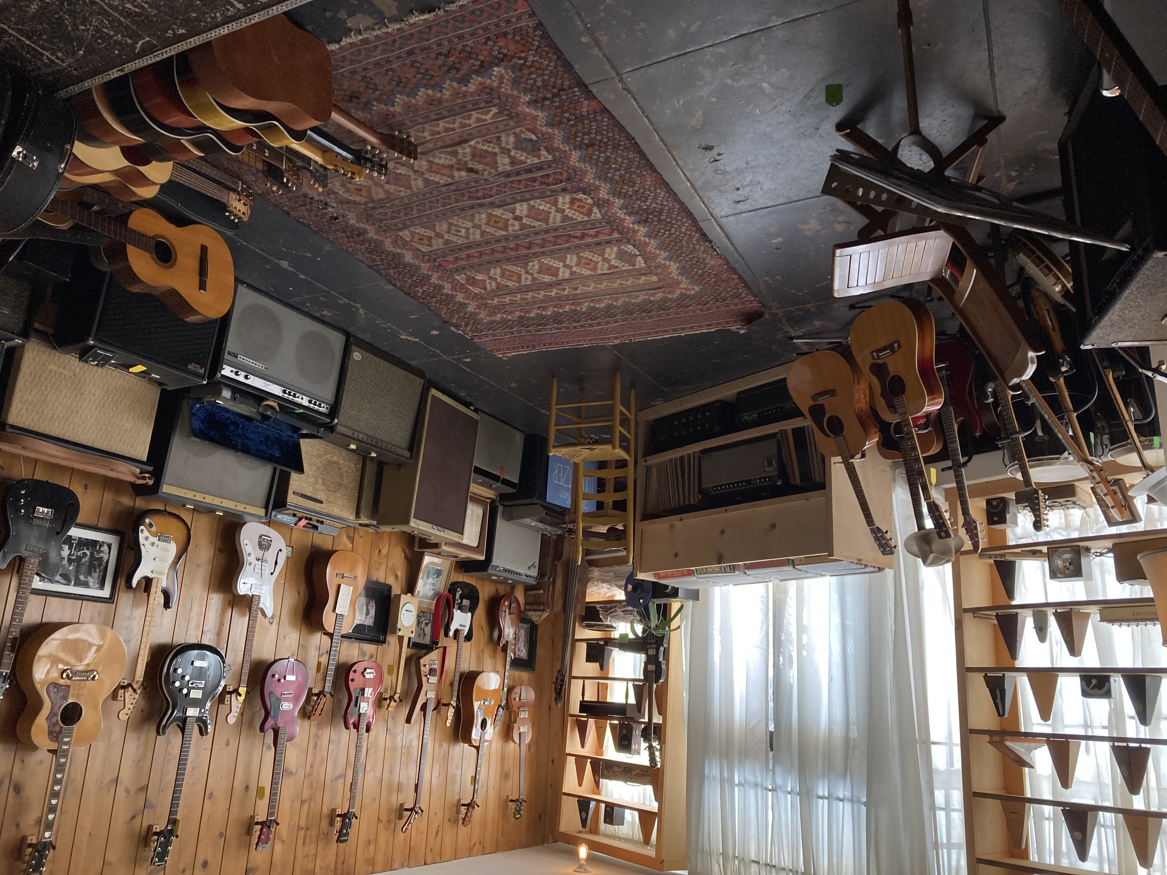 A wall of catalog guitars and vintage amps at Old Style Guitar Shop