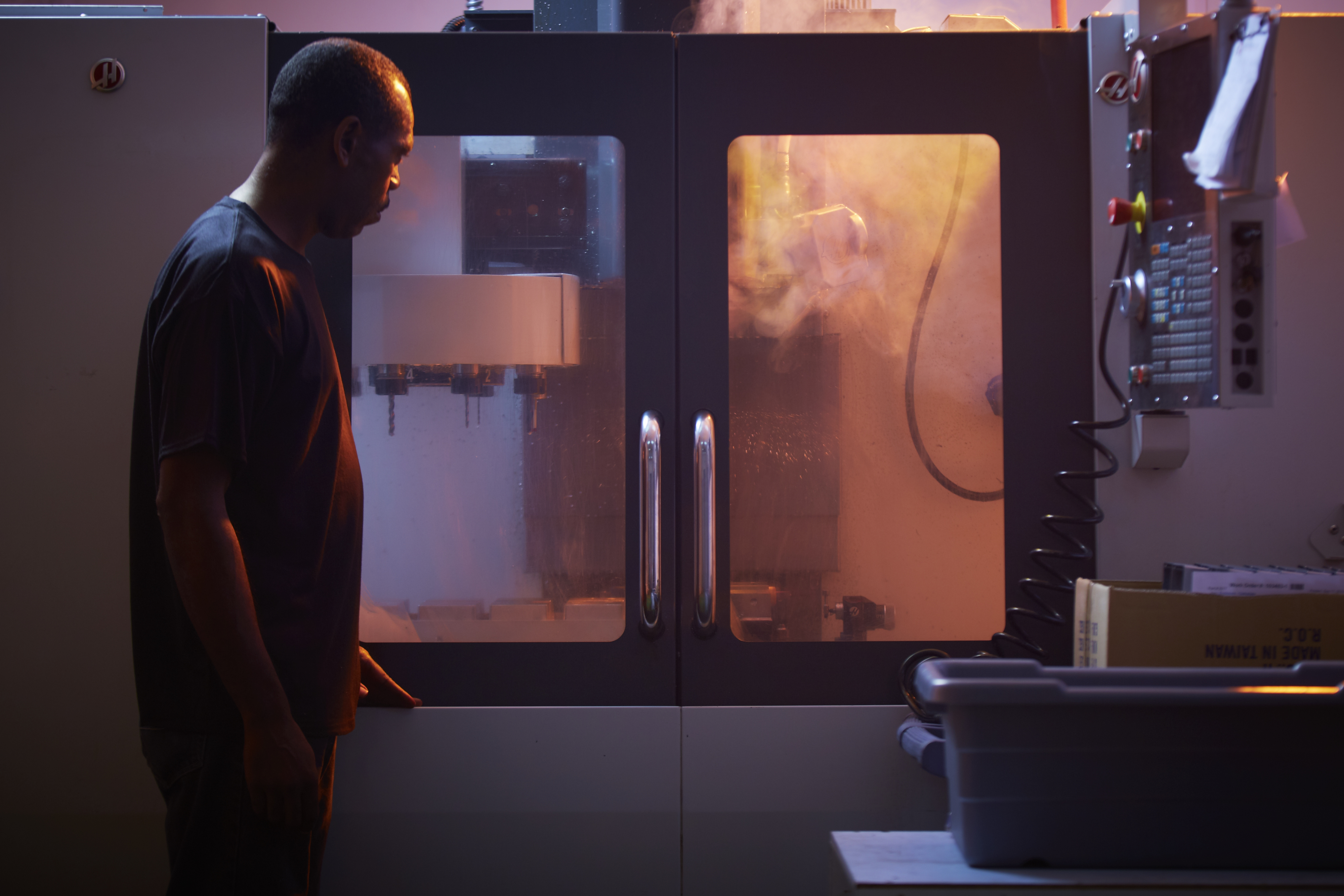 An employee inspects the enclosures as it passes through the CNC machine.