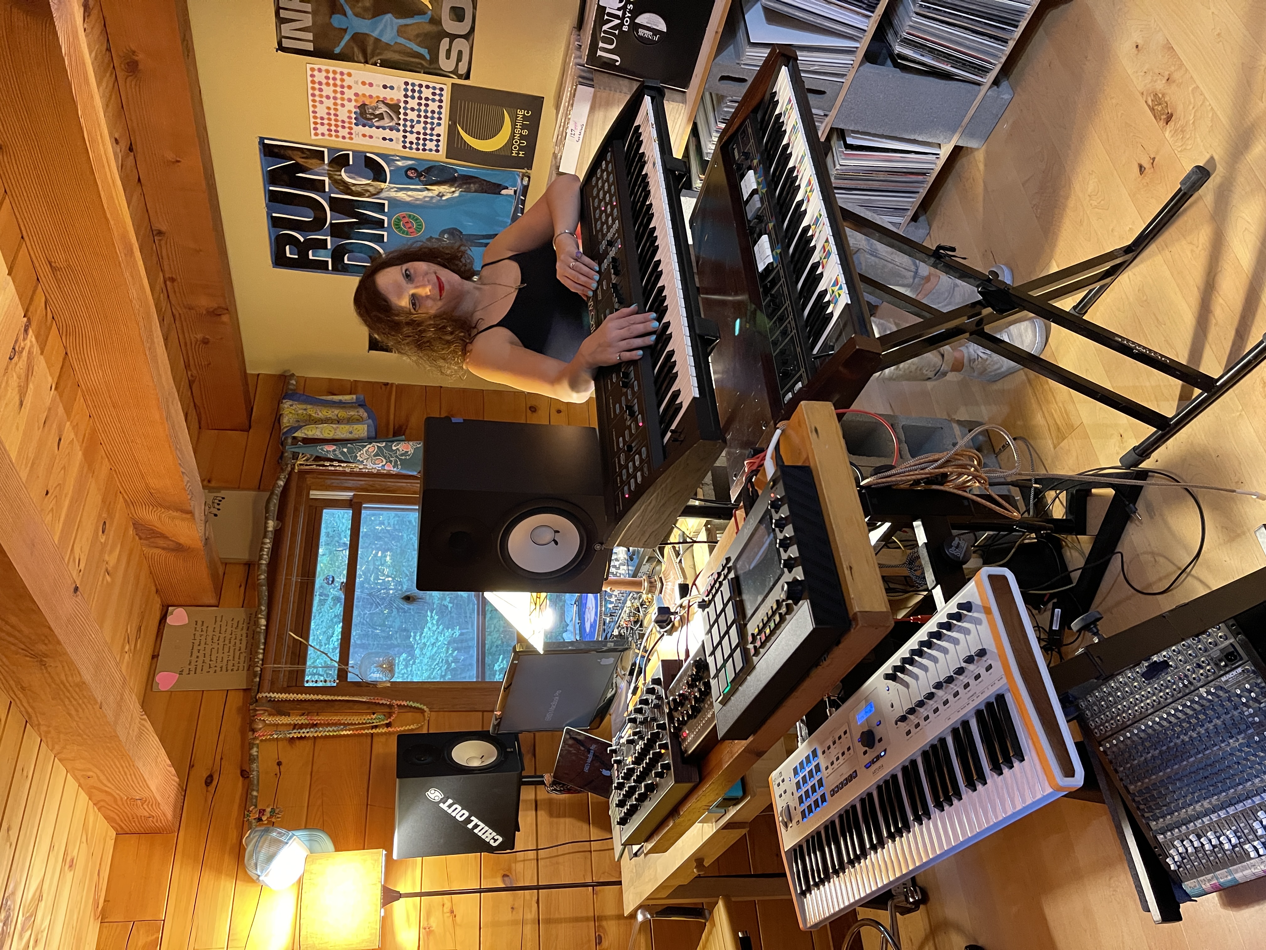 Eris posing with some synths in her home studio.