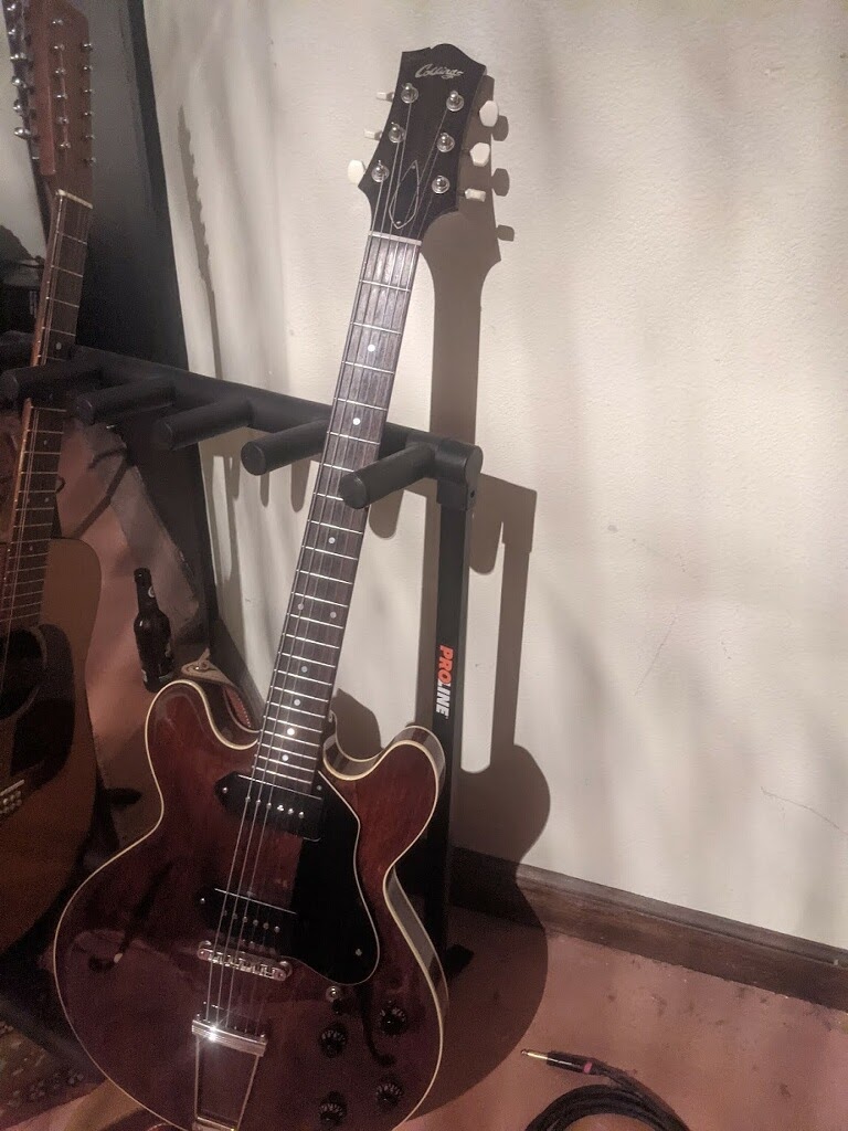 red collings on a guitar stand