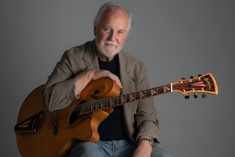 John Monteleone portrait photo with a guitar on his lap