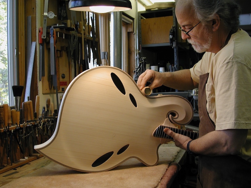 john crafting a guitar body, profile view