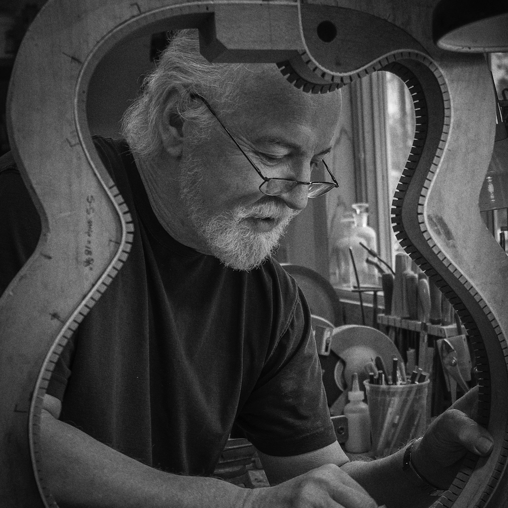 John Monteleone crafting a guitar body in black and white