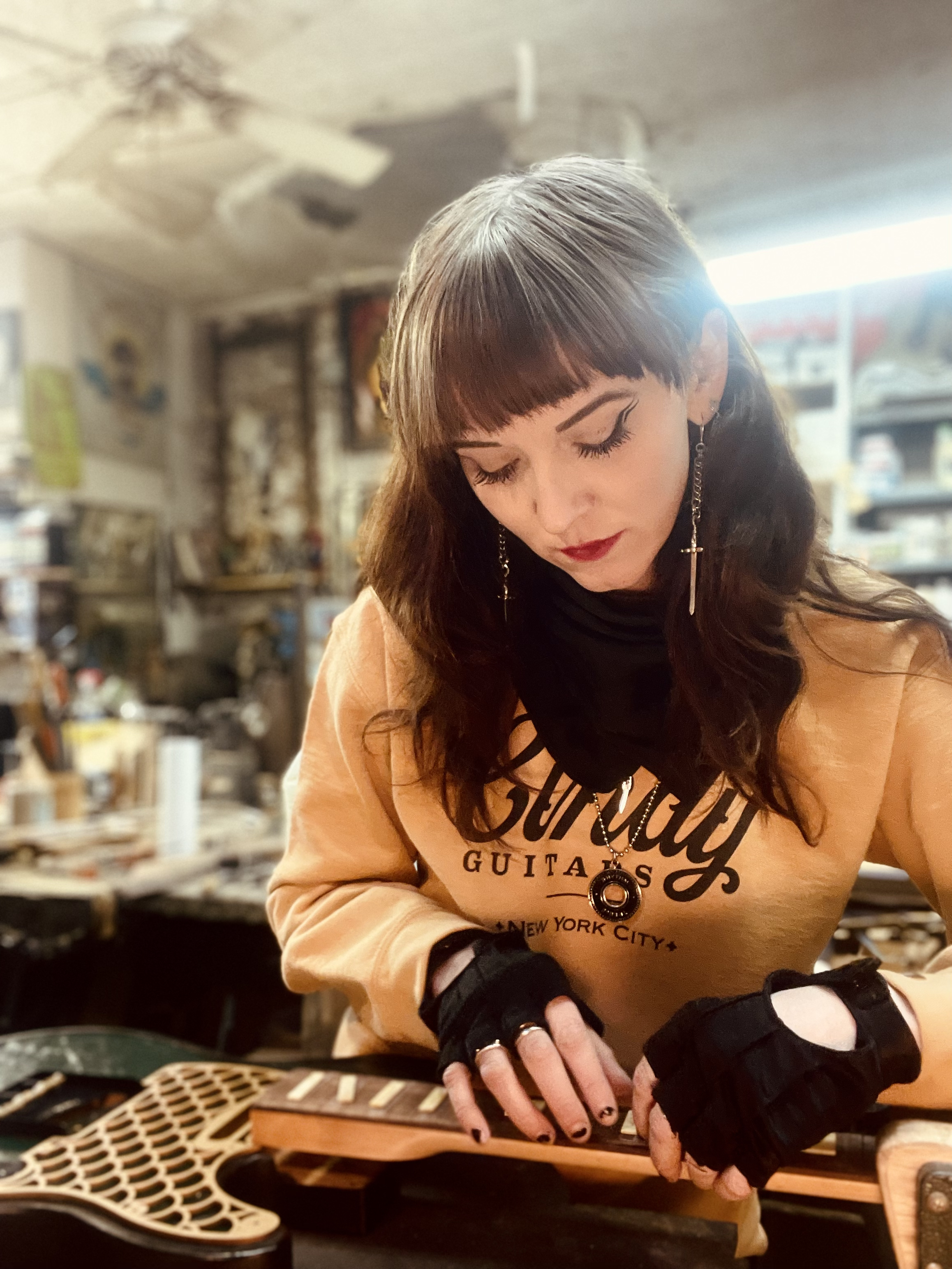 cindy huleg working on a guitar