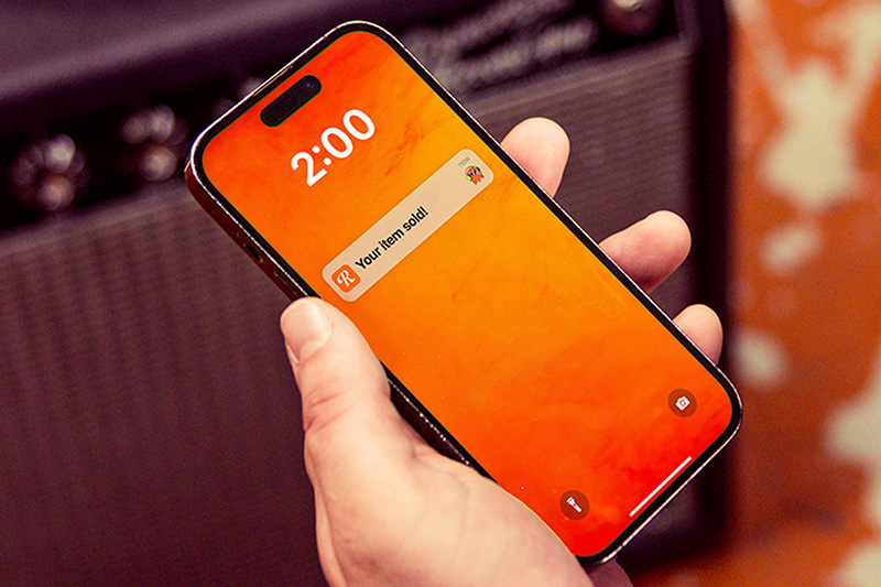A phone screen displays a push notification that says Your item has sold