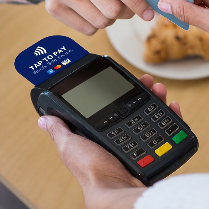 Shop assistant helping customer to pay with a chip and pin device