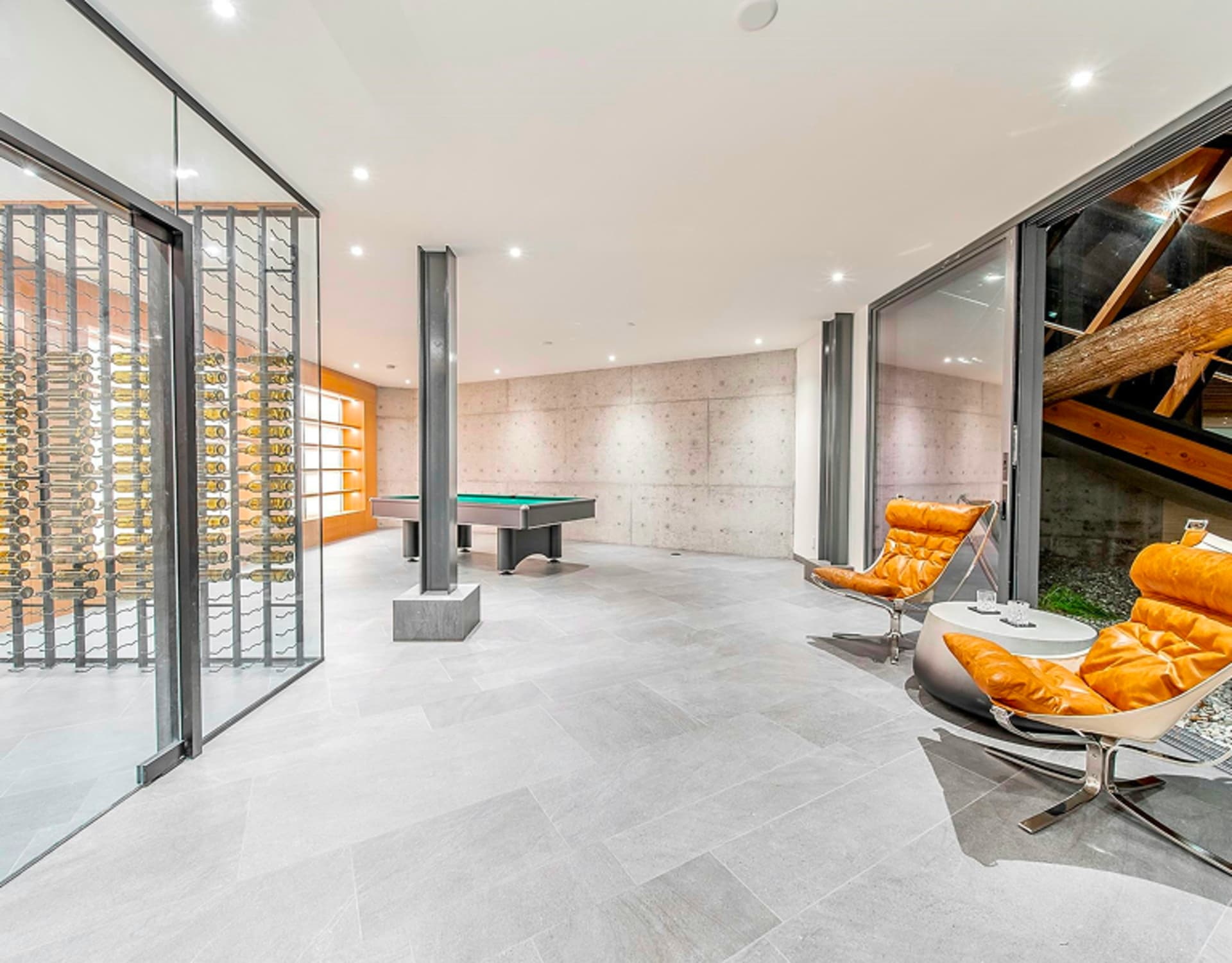 A room with a pool table and wine cellar.