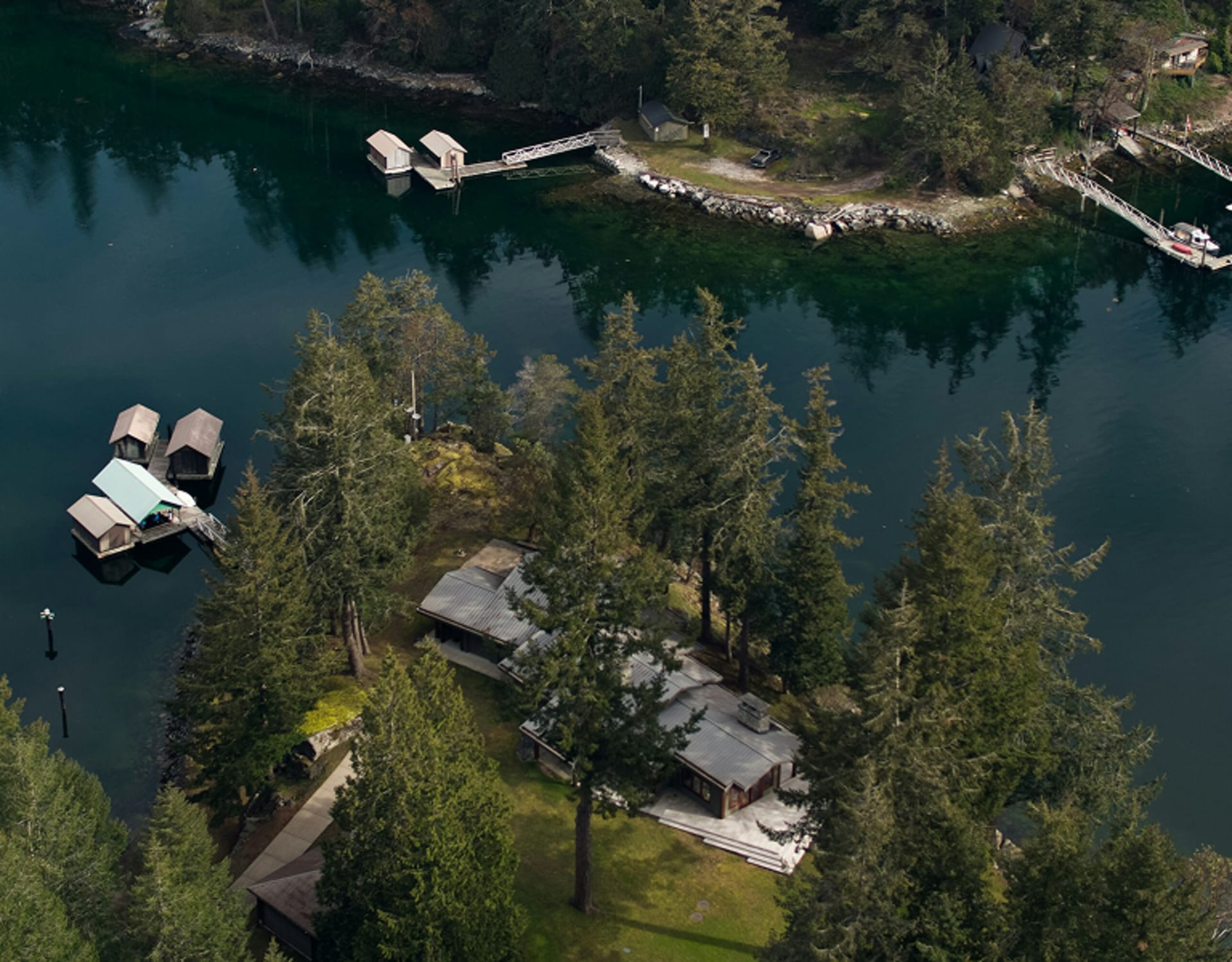 A lakeside home with a wooden dock extending into the waters.