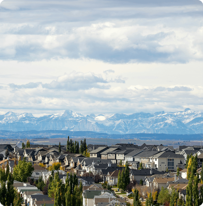 A suburban neighbourhood against a backdrop of snow-capped mountains.